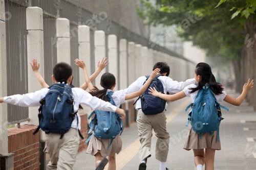 Preview: Rear view of lively schoolchildren in uniform on the way to school