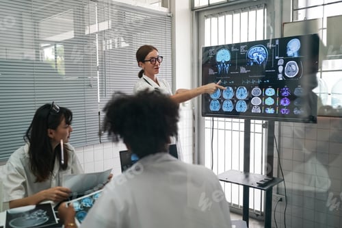 Preview: Group of doctors looking at X-ray on medical conference, discussing issues