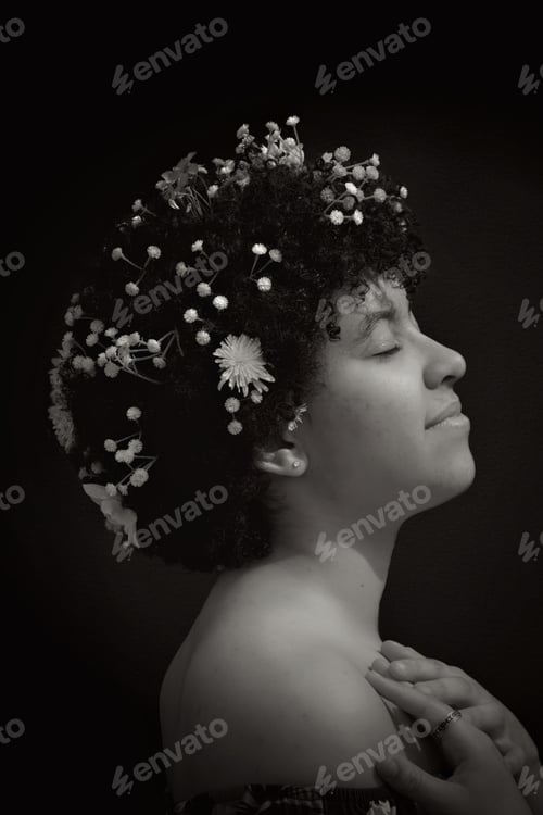 Preview: Beautiful mixed race young woman with flowers in her afro hair