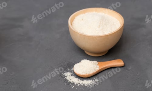 Preview: almond flour in wooden bowl and in a wooden spoon. copy space. alternative flour