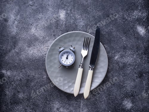 Preview: Grey alarm clock in empty plate.