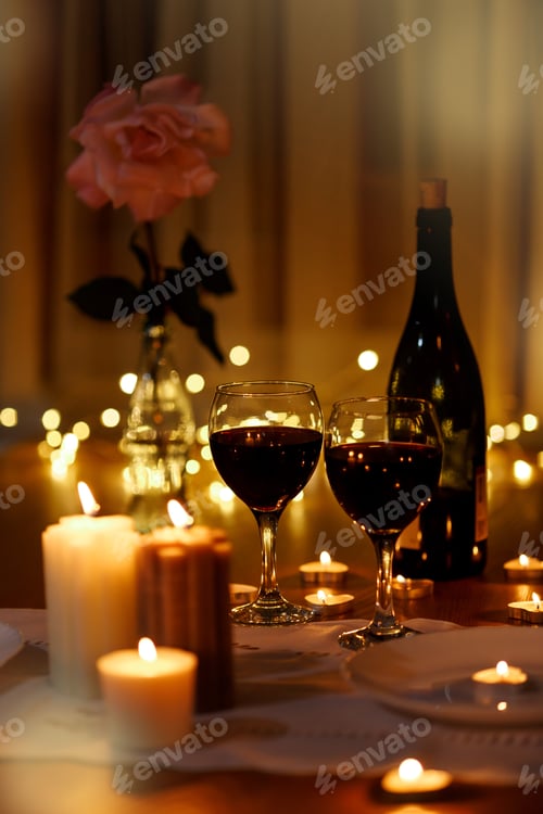 Preview: Two Glasses Of Red Wine Standing On Table With Candles and bottle