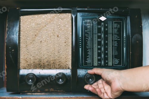 Preview: Woman hand adjusting the button vintage radio receiver