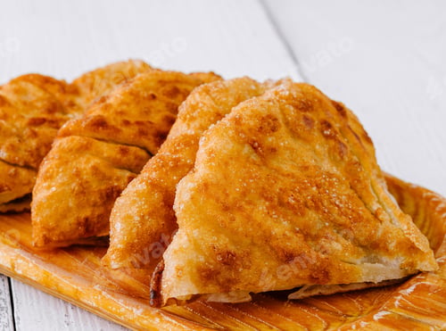 Preview: Delicious fried pies with golden crust lying on wooden board