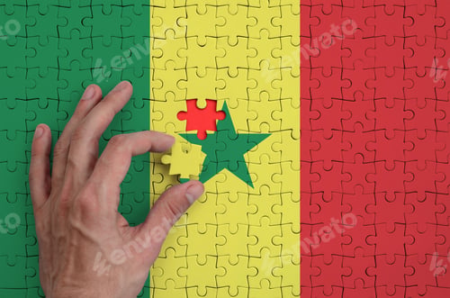 Preview: Senegal flag is depicted on a puzzle, which the man's hand completes to fold.