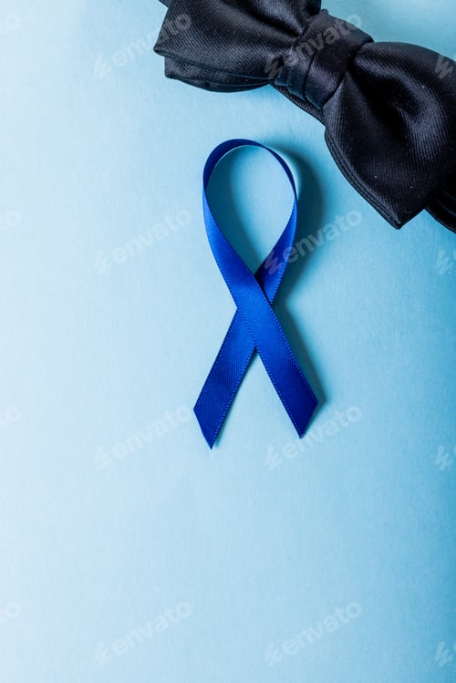 Preview: Directly above shot of blue prostate cancer awareness ribbon with black bowtie on blue background
