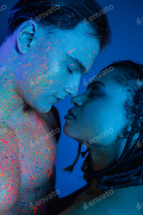 Preview: impassioned interracial couple standing face to face with closed eyes, bare-chested man and african