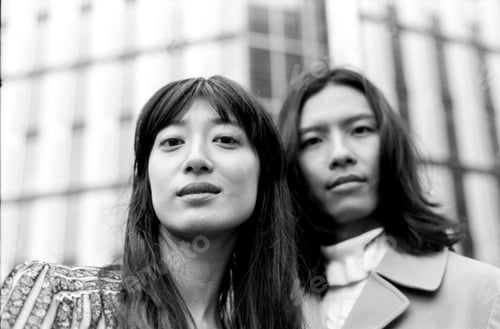 Preview: Young couple posing in front of modern architecture in monochrome film style
