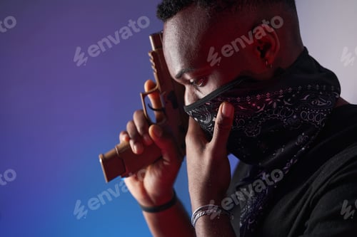 Preview: Man adjusting his face neck mask while holding gun