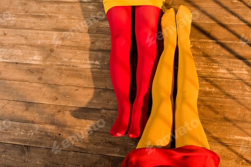 Preview: cropped image of women in colorful tights and dresses sitting on floor at home