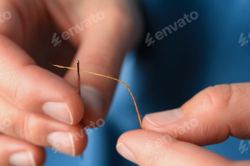 Preview: Closeup view of woman threading sewing needle