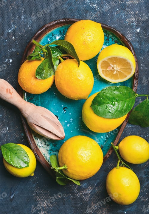 Preview: Freshly picked lemons with leaves in bright blue ceramic plate