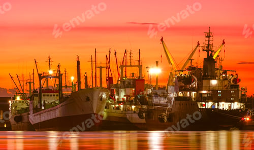Preview: Group of fishing boats and oil tanker ship dock at harbor against beautiful twilight sky background
