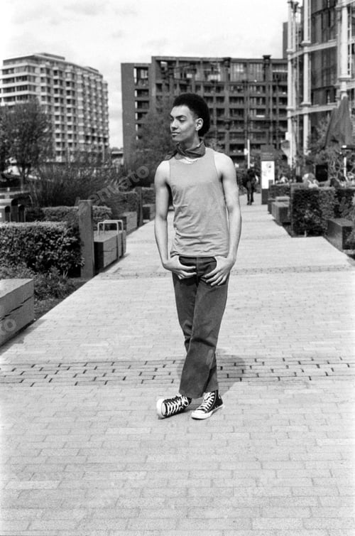 Preview: Young man posing in urban setting wearing tank top and jeans in monochrome analog vintage style