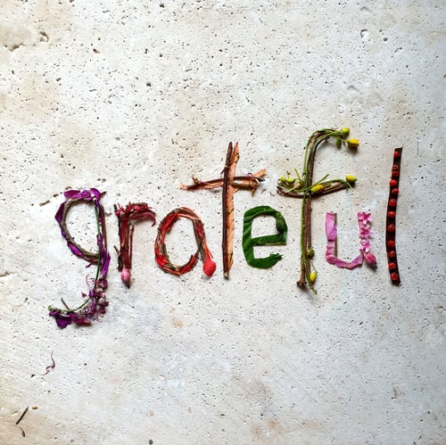 Preview: Grateful,creative text made with flowers on stone table