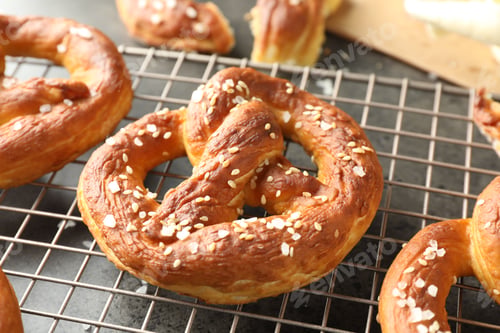 Preview: Tasty pretzels with salt on grey table, closeup