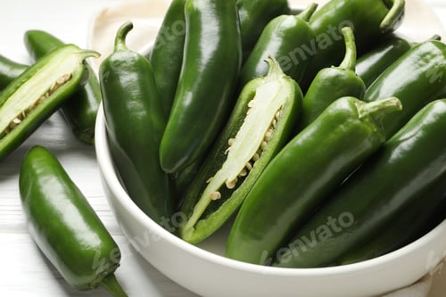 Preview: Fresh jalapeno peppers in bowl on white wooden table, closeup