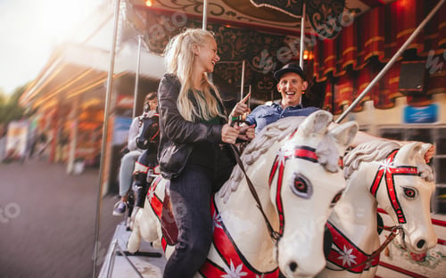Preview: Young couple on amusement park carousel