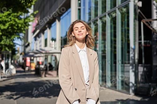 Preview: Portrait of young beautiful corporate woman in beige suit, smiling and looking confident, standing