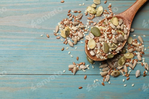 Preview: Mix of seeds in spoon on wooden table, top view. Space for text