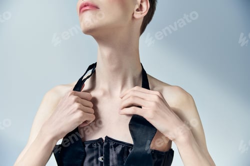Preview: cropped, queer model with makeup touching tie on neck and posing on grey, beauty, androgynous