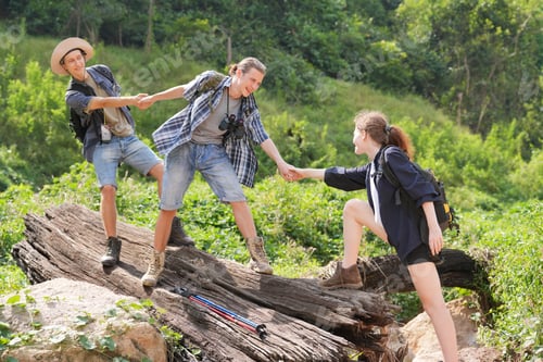 Preview: Hikers walking along a trail on a mountain with hiking sticks