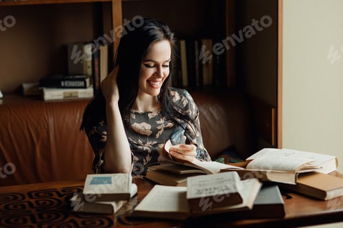 Preview: the young girl reads with a smile a book in the cafe