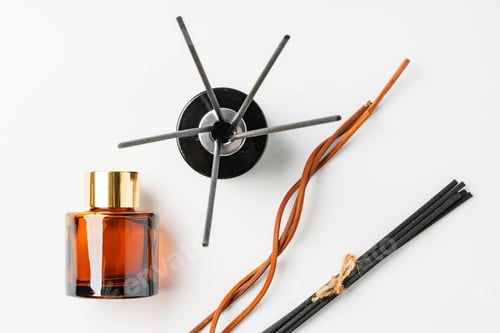 Preview: A minimalist display of essential oil and black diffuser sticks on a clean white background