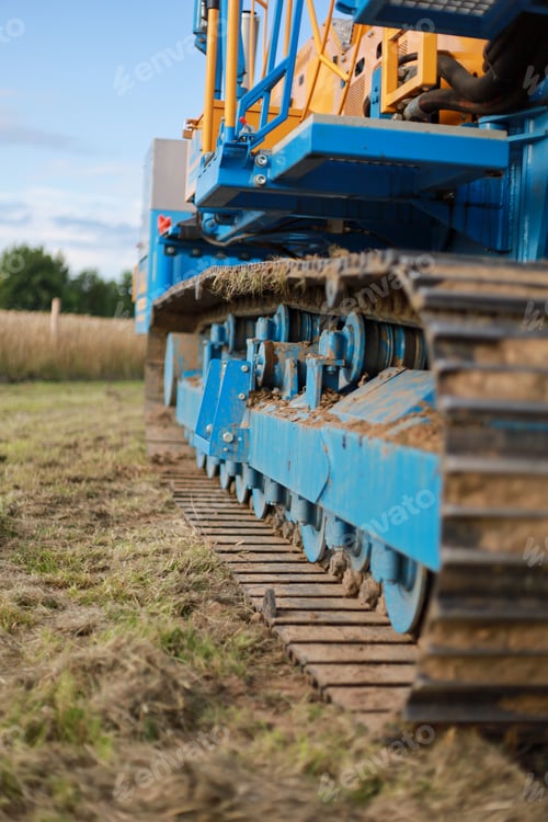 Preview: Vertical shot of large industrial machinery on a meadow