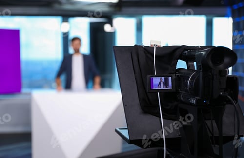 Preview: Presenter working in studio, focus on video camera