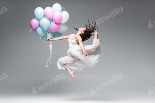 Preview: beautiful ballerina in white dress dancing with festive balloons on grey background