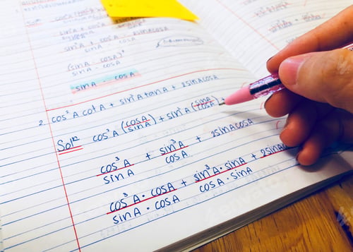 Preview: Student holding pen in hand doing homework mathematic at home