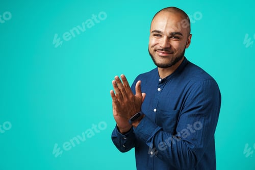 Preview: Smiling african american man clapping his hands and looking at camera