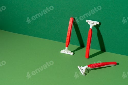 Preview: Disposable razor on green background, studio shot