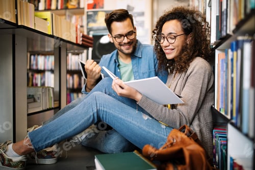 Preview: Group of happy students reading books and preparing to exam in library