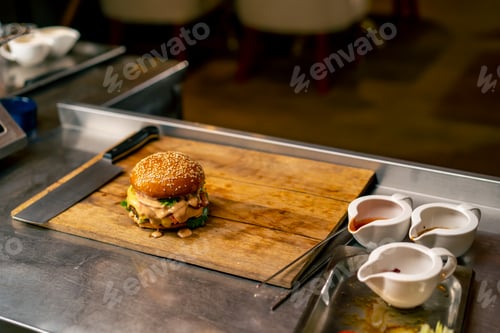 Preview: A close-up of a burger with beef patty with vegetables and cheese cooked in the professional kitchen