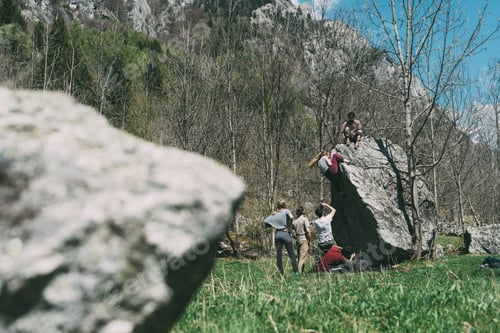 Preview: Adult bouldering friends climbing boulder, Lombardy, Italy
