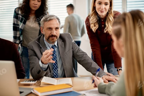 Visualização: Professor maduro se comunicando com estudantes universitários na sala de aula.