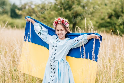Preview: Ukrainian child girl in embroidered shirt vyshyvanka with yellow and blue flag of Ukraine in field.