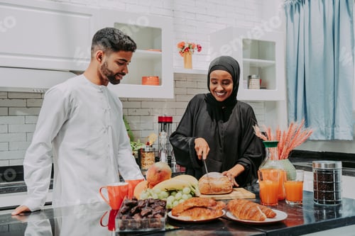 Preview: Happy middle eastern couple wearing traditiona larab clothing at home