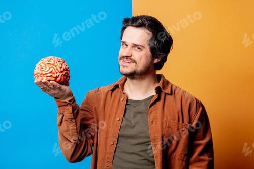 Preview: Guy in shirt hold human brain on yellow and blue backgrounds