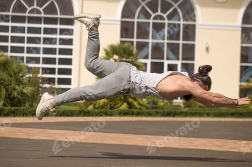 Preview: Young man in sporty wear alone working out doing extreme pushups