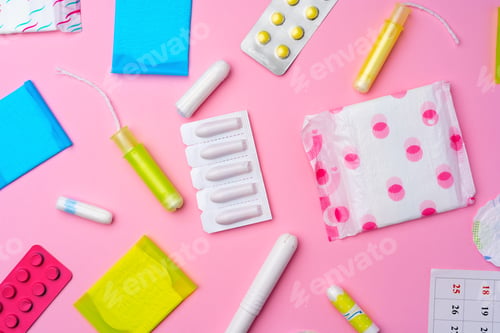 Preview: Сontraceptive pills, hygienic pads and tampons on pink background
