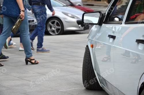 Preview: Diagonal view of a white glossy car that stands on a square of gray tiles