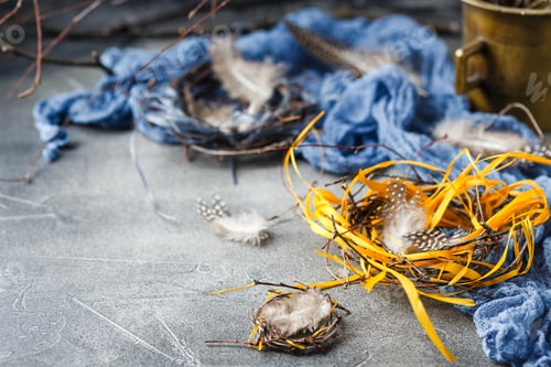 Preview: Quail easter eggs with feathers in nest on brown table with copy space