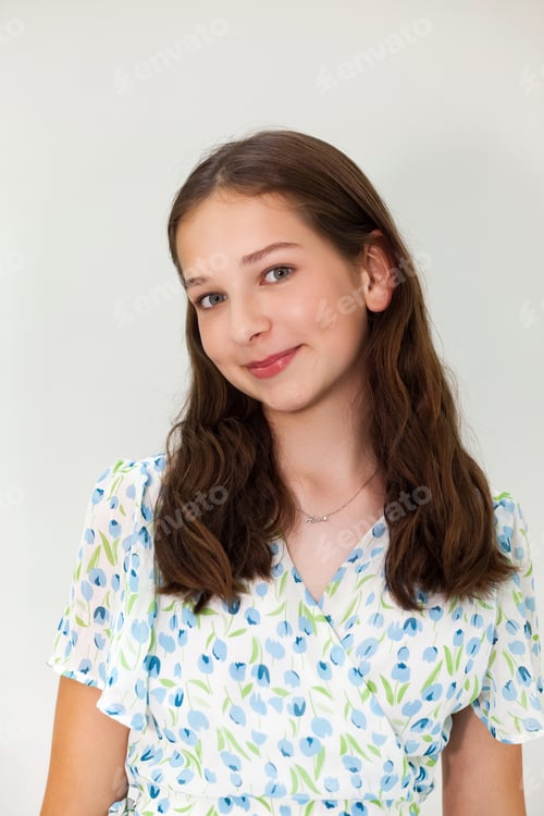Preview: Young Teenage Girl With Long Brown Hair Smiling in a Floral Dress Indoors