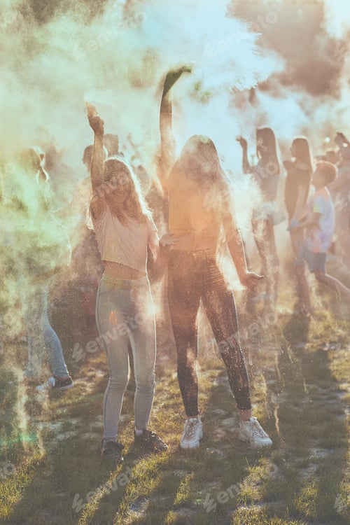 Preview: Portrait of happy smiling young girls with colorful paints on faces and clothes