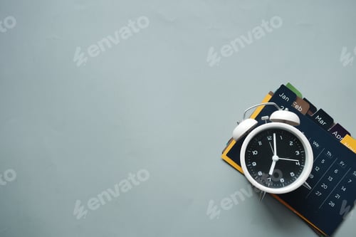 Preview: old alarm clock and a calendar on gray background