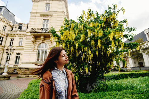 Preview: stylish gorgeous hipster girl traveling in europe city in sunny spring time