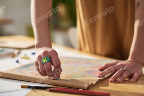 Preview: Close-up of young creative female artist with blue crayon drawing sketch